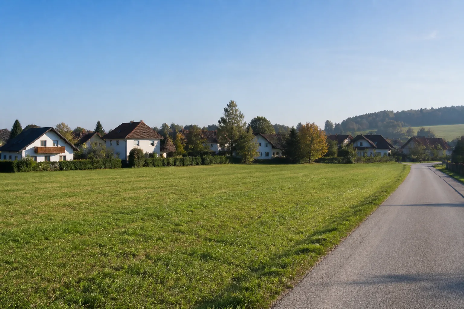 Offene österreichische Fläche neben einem gewachsenen Siedlungsrand und einer bestehenden Straße